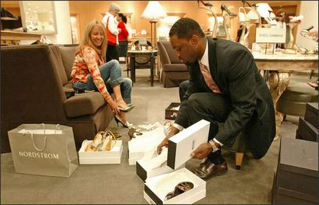Sales associate Derek Henderson brings shoes to Kathleen Greer-Wilkes ...