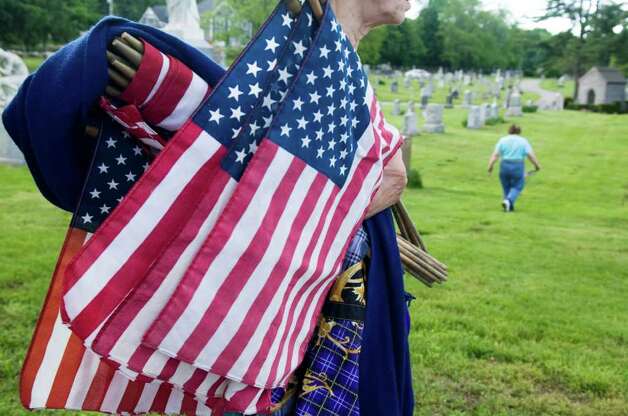  and other volunteers place American flags on veterans graves ...