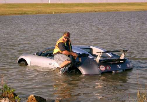 Wrecker driver Gilbert Harrison prepares to retrieve a million-dollar Bugatti Veyron from the water in La Marque in 2009. The driver said he was startled by a pelican. Photo: Chris Paschenko, Galveston County Daily News