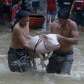 Residents carry a pig through a street flooded by Typhoon Nesat in.... photo: 1630324 slideshow 31095