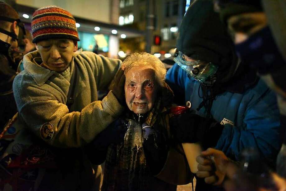 Seattle activist Dorli Rainey, 84, reacts after being hit with pepper spray during an Occupy Seattle protest on Tuesday, November 15, 2011 at Westlake Park. Protesters gathered in the intersection of 5th Avenue and Pine Street after marching from their camp at Seattle Central Community College in support of Occupy Wall Street. Many refused to move from the intersection after being ordered by police. Police then began spraying pepper spray into the gathered crowd hitting dozens of people. A pregnant woman was taken from the mele in an ambulance after being struck with spray. (Joshua Trujillo, seattlepi.com) Photo: Joshua Trujillo