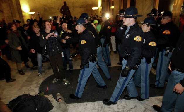 Washington State Patrol troopers use tasers to control a crowd of protestors