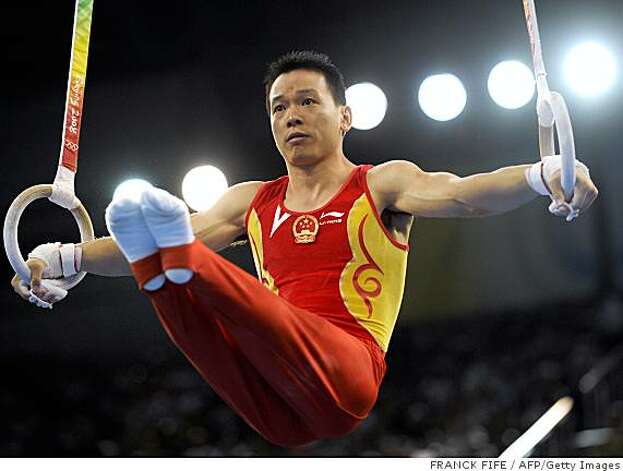 China's Xu Huang competes on the rings during the men's team final of ...