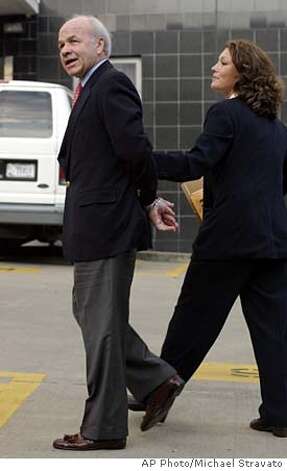 Former Enron CEO Kenneth Lay, left, is led into Federal Court by a law enforcment officer in Houston Thursday July 8, 2004.Lay had been indicted Wednesday after a federal investigation that has produced charges against some of Lay's once most highly trusted lieutenants, including his hand-picked protege, former CEO Jeffrey Skilling. (AP Photo/Michael Stravato)