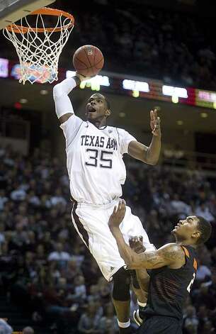 Texas A&amp;M's Ray Turner dunks the ball over Oklahoma State's Le'Bryan Nash uring the first half of an NCAA college basketball game at Reed Arena in College Station, Texas, Saturday, Jan. 28, 2012.  (AP Photo/Bryan-College Station Eagle, Stuart Villanueva) Photo: Stuart Villanueva, Associated Press / Bryan College Station Eagle