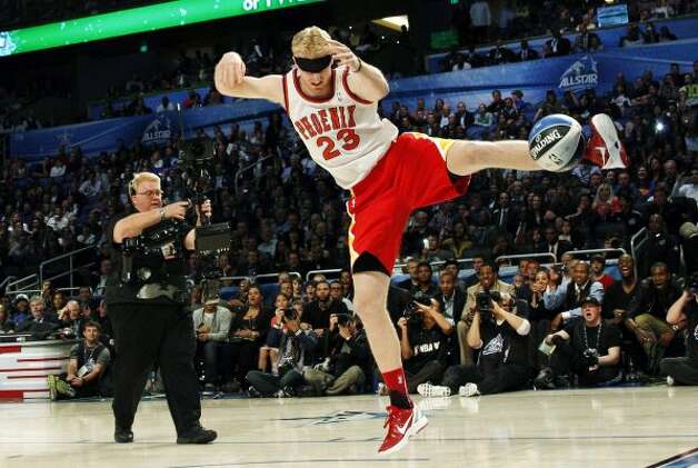Houston Rockets' Chase Budinger follows through on a blindfolded dunk in honor of former Phoenix Suns' Cedric Ceballos, who performed a blindfolded dunk in 1992, during the NBA basketball All-Star Slam Dunk contest, Saturday, Feb. 25, 2012, in Orlando, Fla. (AP Photo/Lynne Sladky) (AP) / SA