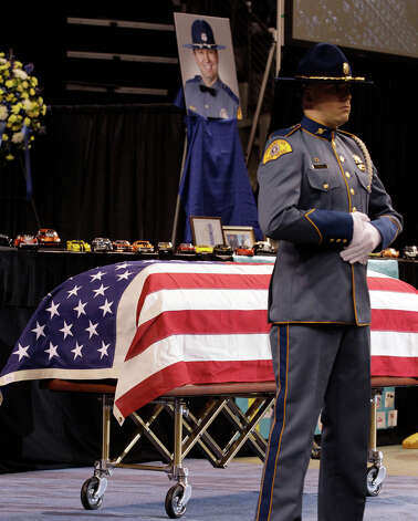 A Washington State Patrol trooper stands guard at the casket of Trooper Tony