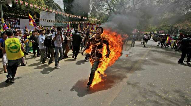 A Tibetan exile man, identified as Jampa Yeshi, runs engulfed in flames after self-immolating during a demonstration in New Delhi, India, Monday, March 26, 2012. Yeshi lit himself on fire and ran shouting through a protest in the Indian capital Monday, just ahead of a visit by China's president Hu Jintao and following self-immolations in the Himalayan region against Beijing's rule. (AP Photo/Manish Swarup) Photo: Manish Swarup, Associated Press / AP