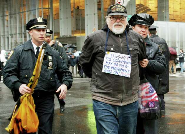 Police escort away a man who was arrested as members of Occupy Wall Street protest during a May Day rally in front of the Bank of America in New York City. Demonstrators have called for nation-wide May Day strikes to protest economic inequality and political corruption. Photo: Monika Graff, Getty Images / 2012 Getty Images