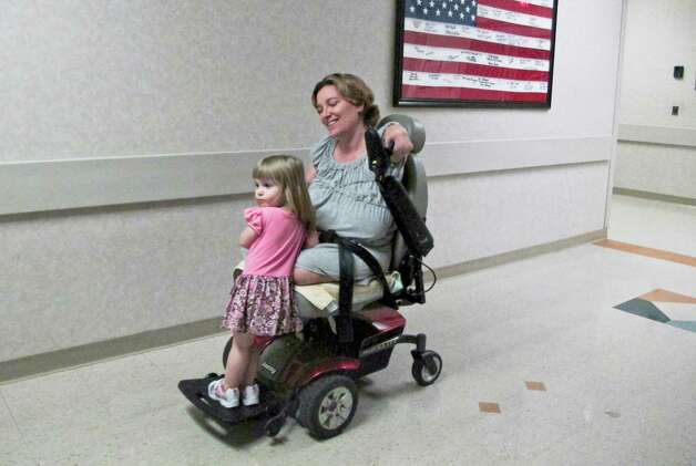 Two-year-old Arielle Hayes  rides with her mother, Katy Hayes, after a radiology appointment  last week at Kingwood Medical Center. Katy lost her limbs to a flesh-eating infection soon after Arielle's birth. Photo: Billy Smith II / © 2012 Houston Chronicle