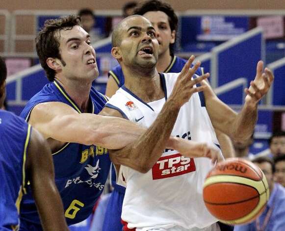 French basketball star Tony Parker, right, is blocked by Murilo Becker Da Rosa of Brazil, left, during the match of the 2006 Stankovic Continental Champions Cup Tuesday Aug. 15, 2006 in Kunshan, China. France won over Brazil 86-74. (Eugene Hoshiko / Associated Press) / SA