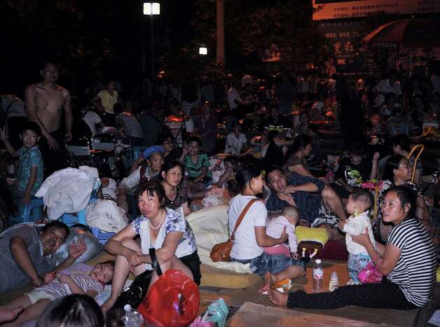 People gather at a square following an earthquake in Zhaotong town, Yiliang County, southwest China's Yunnan Province on Friday. A series of earthquakes collapsed houses and triggered landslides Friday in a remote mountainous part of southwestern China where damage was preventing rescues and communications were disrupted. At least 64 deaths have been reported. (AP Photo) Photo: Associated Press / SL