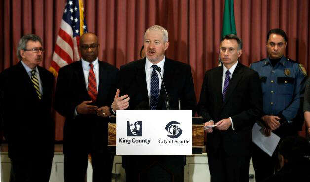 Seattle Mayor Mike McGinn, center, speaks Jan. 8, at a news conference announcing the gun buyback program. Behind him, from left, are former Seattle mayors Charles Royer, and Norm Rice, King Co. Executive Dow Constantine, and Seattle Deputy Police Chief Nick Metz
