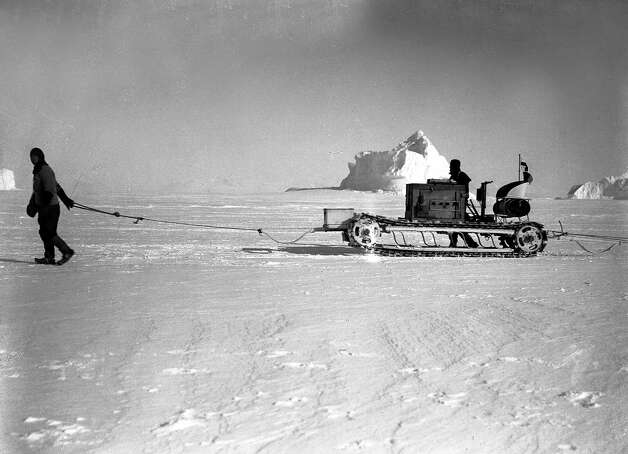 Lieutenant Evans guiding Bernard Day's motor tractor, laden with food and supplies, past the bergs on their Southern journey. Photo: Popperfoto, H.G. Pointing/Terra Nova / Popperfoto
