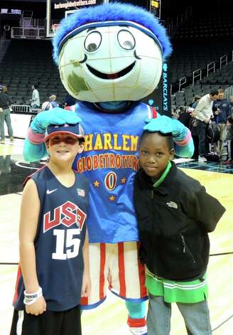 Donte McKenzie, a Fresh Air Fund child from Brooklyn, N.Y., right, and Tobey Sappern of Fairfield stand with the Harlem Globetrotters mascot before a game last summer at the Barclay Center in Brooklyn, N.Y. The Sappern family hosted McKenzie for a wek last August and plan on hosting him again for another week this August. Photo: Contributed Photo