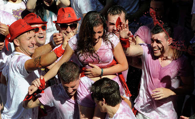 Participants celebrate during the 'Chupinazo' marking the start of the San Fermin Festival on July 6, 2013 in front of the Town Hall of Pamplona, northern Spain. A red-and-white ocean of revelers erupted in cheers to launch Spain's annual San Fermin bull-running festival today but only after a 19-minute delay caused by a giant Basque flag that blocked the starting rocket. Photo: RAFA RIVAS, AFP/Getty Images / 2013 AFP