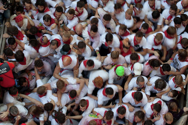 A crowd of runners go behind the Alcurrucen's ranch fighting bulls entering the bullring during the second day of the San Fermin Running Of The Bulls festival on July 7, 2013 in Pamplona, Spain. The annual Fiesta de San Fermin, made famous by the 1926 novel of US writer Ernest Hemmingway 'The Sun Also Rises', involves the running of the bulls through the historic heart of Pamplona, this year for nine days from July 6-14. Photo: Pablo Blazquez Dominguez, Getty Images / 2013 Getty Images