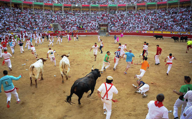 Participants run in front of Dolores Aguirre's bulls during a bull run of the San Fermin Festival in Pamplona, northern Spain, on July 8, 2013. The festival is a symbol of Spanish culture that attracts thousands of tourists to watch the bull runs despite heavy condemnation from animal rights groups. Photo: PEDRO ARMESTRE, AFP/Getty Images / 2013 AFP