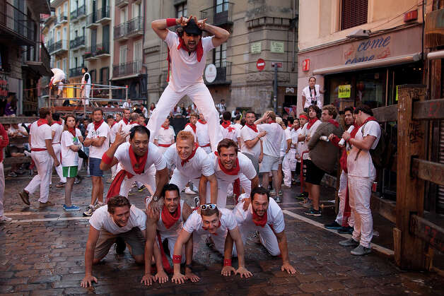 Revellers form a human tower to pose for a picture in the early hours ahead of Dolores Aguirre's ranch fighting bulls running on the third day of the San Fermin Running Of The Bulls festival, on July 8, 2013 in Pamplona, Spain. The annual Fiesta de San Fermin, made famous by the 1926 novel of US writer Ernest Hemmingway 'The Sun Also Rises', involves the running of the bulls through the historic heart of Pamplona for nine days from July 6-14. Photo: Pablo Blazquez Dominguez, Getty Images / 2013 Getty Images