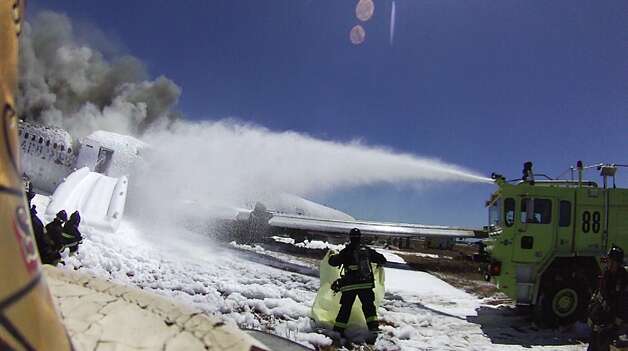 An image from the helmet-mounted video camera of a San Francisco fire battalion chief at the scene of the crash of Asiana Flight 214 shows a firefighter covering the body of passenger Ye Meng Yuan at San Francisco International Airport on July 6, 2013 in San Francisco, California.