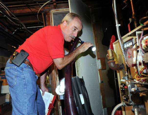 G. Neil Scott  inspects the oil burner in the basement at a McArthur Lane home in Stamford, Tuesday, August 13, 2013. Scott is the owner of Scott and Scott Home Inspection Services Inc., of Stamford. Photo: Bob Luckey / Greenwich Time