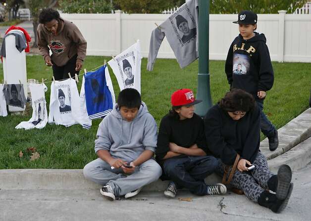 Tonia Coleman hangs clothing printed with Andy Lopez Cruz's image while Fernando Alducin (center), Cristian Sev, Marisol Hernandez and Carlos Sev wait outside Andy's viewing service in Windsor. Photo: Raphael Kluzniok, The Chronicle