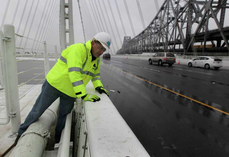 Caltrans engineer Bill Casey inspects for water leakage along the steel safety barrier on the deck of the new eastern Bay Bridge span (Photo: Paul Chinn / The Chronicle)