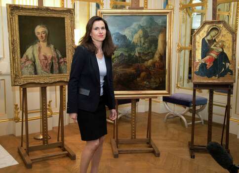 France’s culture minister Aurelie Filipetti, arrives at a ceremony at the Culture Ministry in Paris, Tuesday, March 11, 2014, to return three paintings taken from their owners during World War II, background. The restitution is part of France's ongoing effort to return hundreds of looted artworks that Jewish owners lost during the war that still hang in the Louvre and other museums. Photo: Michel Euler, AP / AP