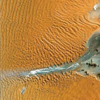 Namib Desert, Namibia – Here, southwest winds have created the tallest sand dunes in the world, with some dunes reaching 300 meters in height. Photo: Boyd, John, Source: "Earth As Art," Published By NASA