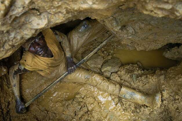 MONGWALU, CONGO Ð JUNE 9:  A man at the bottom of a gold mine uses a long metal rod to jab away at the rock, mud and dirt in the hopes to discover a vein of gold running through the hills of the northeastern Democratic Republic of Congo on June 9, 2006. Although the Congo is one of the richest countries in the world in terms of mineral wealth, most people still live without running water or electricity.
Photo by Daniel Pepper/Special to The Chronicle Photo: Daniel Pepper/Special To The Chr, SFC
