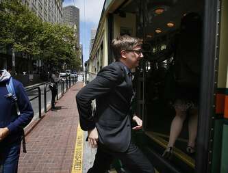 San Francisco Cultural Affairs Director Thomas DeCaigny boards a Muni streetcar while on his way to a meeting at City Hall on July 01, 2014 in San Francisco, CA.