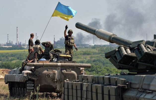 An armoured personnel carrier flying Ukraine's flag (L) and a Ukrainian tank, from a convoy of the Ukrainian forces, drive towards the eastern Ukrainian city of Lysychansk, in the region of Lugansk, on July 25, 2014. Russia on Friday called the latest US accusations of Moscow's involvement in the Ukrainian conflict a baseless "smear campaign" and said Washington bears responsibility for the bloodshed. AFP PHOTO / GENYA SAVILOVGENYA SAVILOV/AFP/Getty Images Photo: GENYA SAVILOV / Genya Savilov