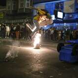 A man leaps over a bonfire the intersection of 19th and Mission Street in San Francisco after the Giants win the World Series on Wednesday, October 29, 2014.