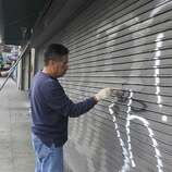 Jaime Najera [right) and his son Jaime Najera Jr., paint over graffiti left by celebrants on a Mission Street business in San Francisco, Calif. on Thursday, Oct. 30, 2014. The celebration turned ugly when crowds became unruly and vandalized several businesses and vehicles after the Giants beat the Kansas City Royals in the World Series.
