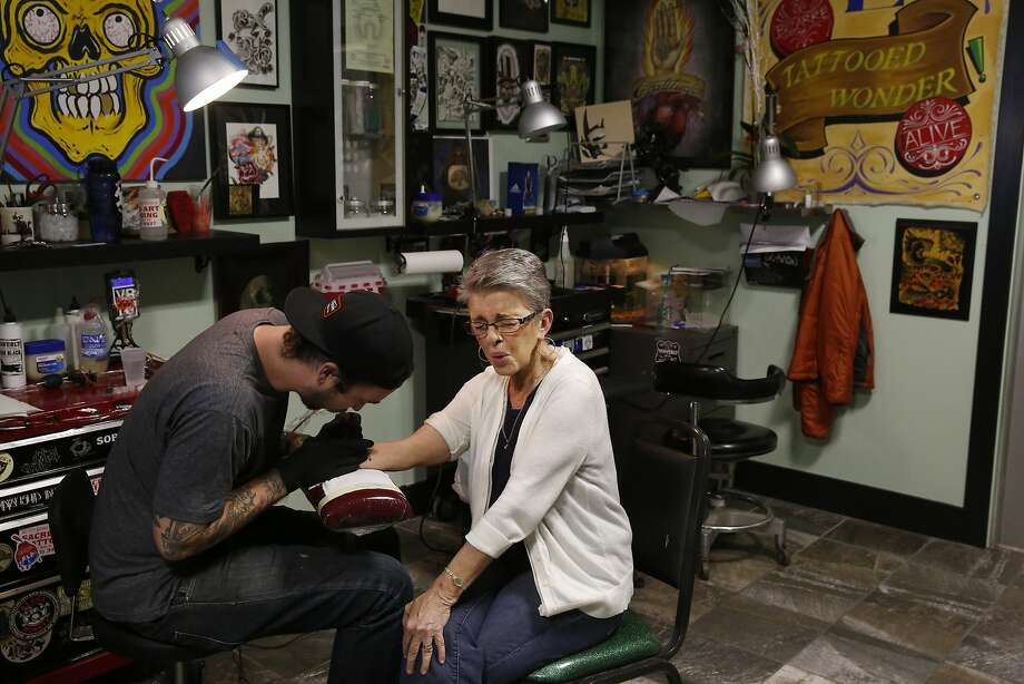 Rustyann Brown reacts to Seth Singletary as he draws her tattoo showing the number of compensation claims she found in a cabinet when she worked at the VA at Sacred Tattoo March 31, 2015 in Oakland, Calif. Brown became a whistleblower last year while working for the Oakland VA after she discovered over 13,000 compensation and disability claims stashed away in a filing cabinet dating back to the early 90s. Since she reported the VA, she says not much has changed within the office. Brown left the VA not long after coming forward with the news and has since been plagued with guilt and concern over the claims. Photo: Leah Millis, The Chronicle