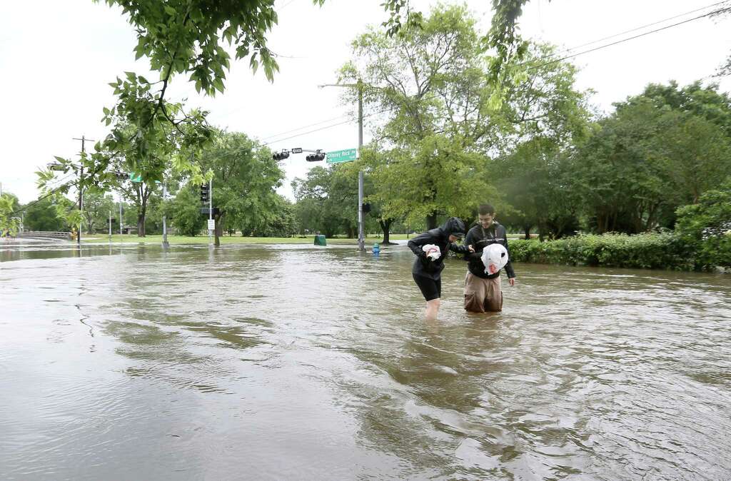 Rotem Magal, right, and Anna Blum navigate a flooded Chimney Rock Road, after Brays Bayou flooded the Meyerland area, Monday, April 18, 2016, in Houston.  Photo: Jon Shapley, John Shapley/Houston Chronicle / © 2015  Houston Chronicle