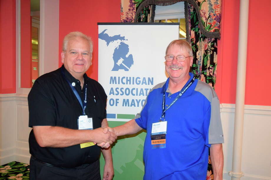 Photo provided Auburn Mayor Lee Kilbourn, left, and Baraga Village President Wendell Dompier shake hands after being elected president and vice president, respectively, of the Michigan Association of Mayors.