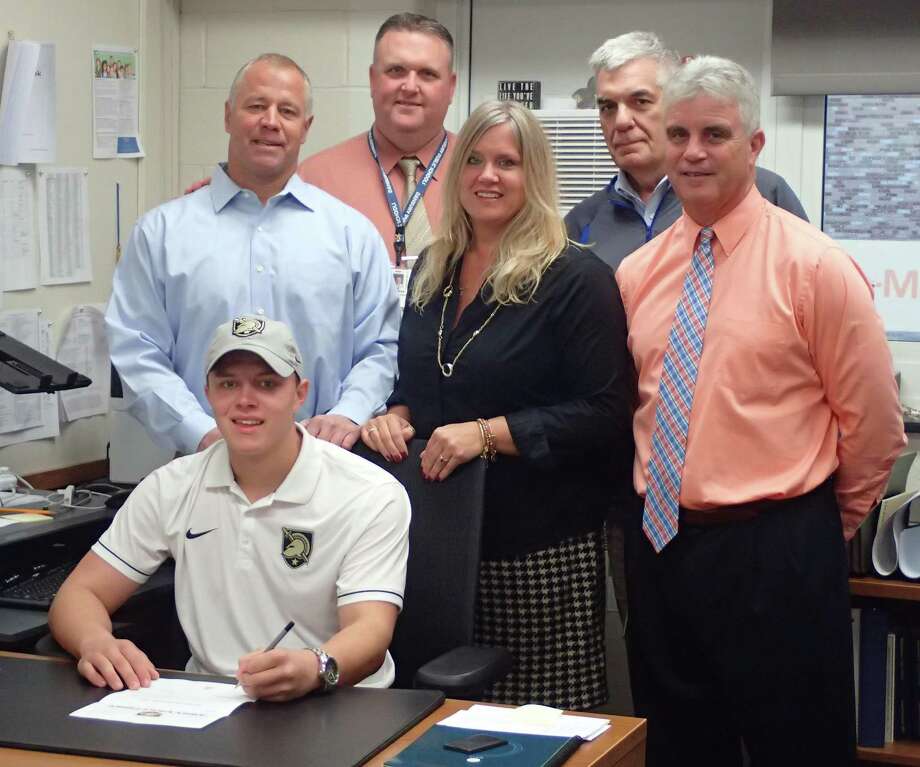 Danbury High School senior Mike Halas, front, signs his National Letter of Intent to play baseball at West Point during a ceremony at the high school on Nov. 15, 2016. Standing behind are his parents Mike, left, and Laura, third from left; along with Danbury High School Principal Dan Donovan, second from left; Danbury High School Athletic Director Chip Salvestrini, second from right; and Danbury High baseball coach Shaun Ratchford, right. Photo: Richard Gregory / Richard Gregory