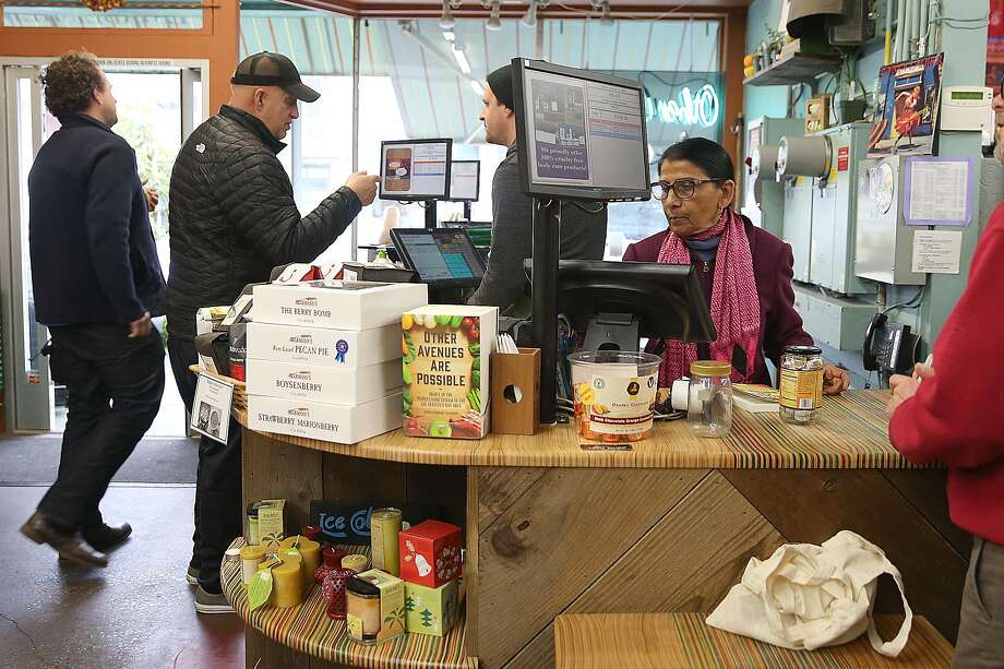Shanta Nimbark Sacharoff (in pink scarf) works behind the counter at Other Avenues co-op in the Sunset District of S.F. Photo: Liz Hafalia, The Chronicle