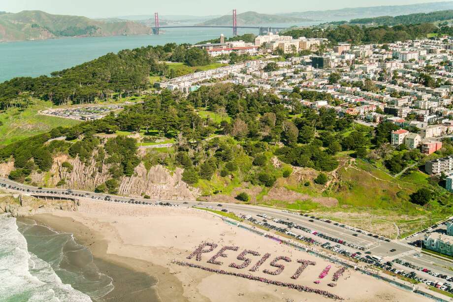 Protesters gather to spell out "Resist!!" on Ocean Beach in San Francisco on Jan. 11, 2017. Photo: Stefan Ruenzel