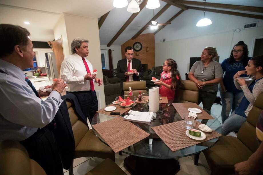 David Calvillo attorney at law and senior counsel at the Chamberlain Hrdlicka law firm, former Texas Supreme Court Justice David Medina and Juan F. Vasquez, Jr. Chamberlain Hrdlicka law firm shareholder share a snack with the Rodriguez family at their home in Houston, Thursday, June 8, 2017. Photo: Marie D. De Jesus, Houston Chronicle / © 2017 Houston Chronicle