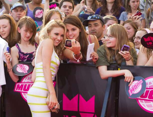 Emily Osment poses for a photograph on the red carpet at the MuchMusic Video