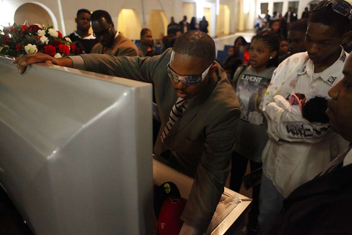 Surrounded by his children Reverend Ramon Price Sr. closes his son Lamont's casket at the end of the funeral service,  Wednesday, February 29, 2012, at Mt. Calvary Baptist Church in Oakland, Calif. Lamont DeShawn Price, 17, was shot four times by people that he knew. "He wasn't an angel, but still we have to do something about these killings," says Price. Photo: Lacy Atkins, The Chronicle
