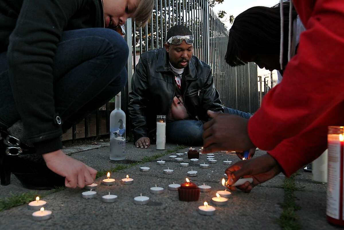 Brijjanna Price, left, joins her father Ramon and friends as they  light candles to mark the one year anniversary of the killing of her brother Lamont, Saturday February 16, 2013, in Oakland, Calif. Lamont Price, 17, was killed in the 8100 block of Birch Street in broad daylight. Photo: Lacy Atkins, The Chronicle