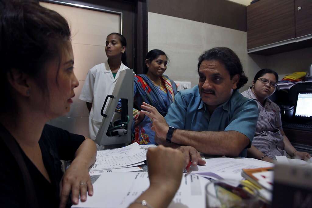 Jennifer Benito-Kowalski, left, reviews the final bill with Dr. Hitesh Patel at the Akanksha Infertility Clinic in Anand, India, Thursday, May 30, 2013. At first  Dr. Patel, claimed that Benito-Kowalski still had a balance owed but late reversed himself and said the clinic owed the couple a refund. Photo: Nicole Fruge, The Chronicle