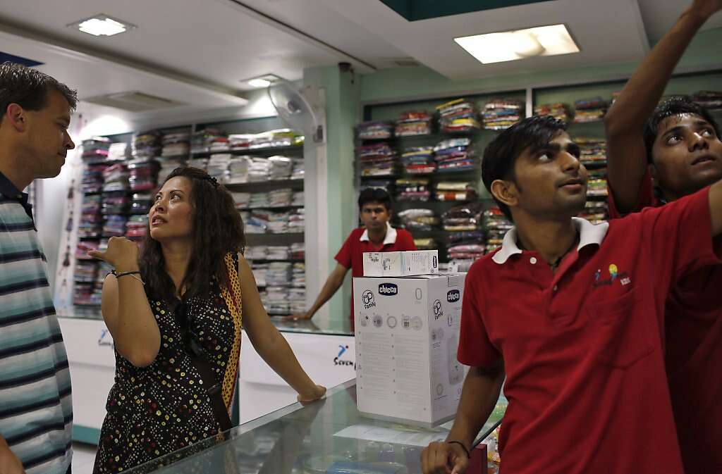 Steve Kowalski (left) and Jennifer Benito-Kowalski buy a bottle sterilizer at a children's store in Anand, India, Thursday, May 23, 2013. Photo: Nicole Fruge, The Chronicle