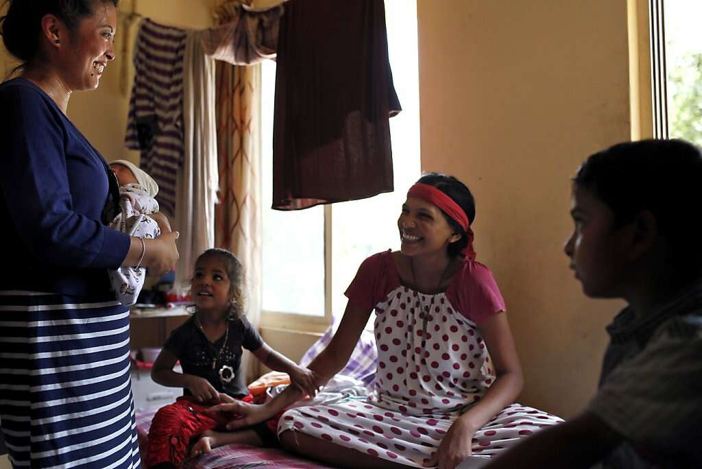 Four days after he was born, Jennifer Benito-Kowalski (left) introduces baby Kyle to surrogate Manisha Parmar and her children, Urvashi, 3, and Tanvay, 8, at the Akanksha Infertility Clinic in Anand, India, Monday, May 27, 2013. Photo: Nicole Fruge, The Chronicle