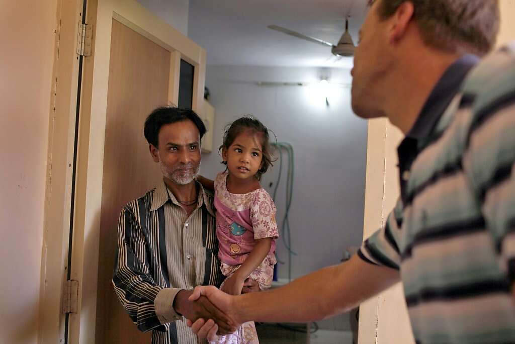 Steve Kowalski (right) thanks surrogate Manisha Parmar's husband, Raman, and daughter, Urvashi, 3, after she delivered a baby boy by cesarean section at the Akanksha Infertility Clinic in Anand, India, Thursday, May 23, 2013. Photo: Nicole Fruge, The Chronicle