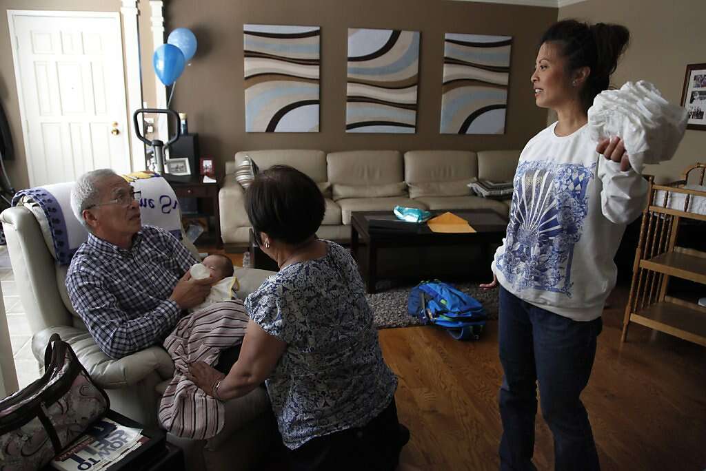 Grandparents Domingo and  Clemencia "Amy" Benito feed baby Kyle as  Jennifer Benito-Kowalski looks on in her home in San Carlos, Calif., Wednesday, August 7, 2013. Photo: Nicole Fruge, The Chronicle