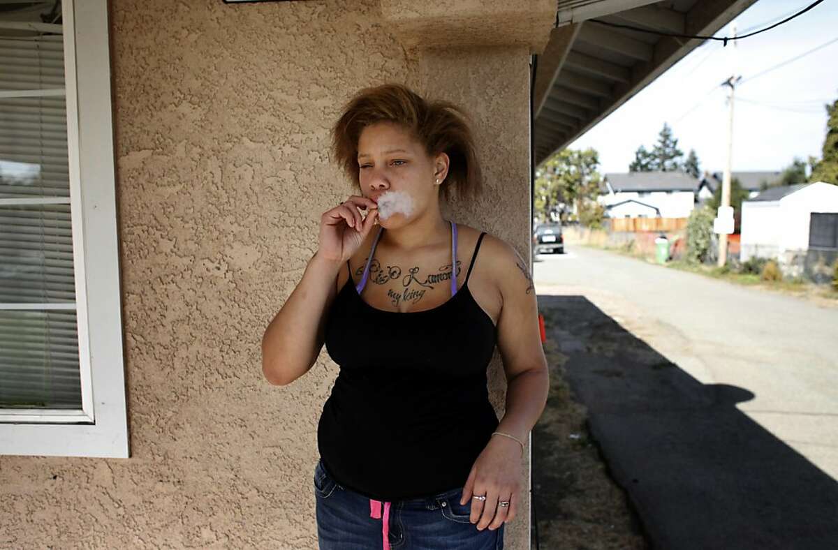 Brijjanna Price tries to calm herself by smoking pot on the front steps of the house she shares with her toddler, her baby's father and his grandmother on Wednesday, November 6, 2013, in Hayward, Calif. Photo: Lacy Atkins, The Chronicle
